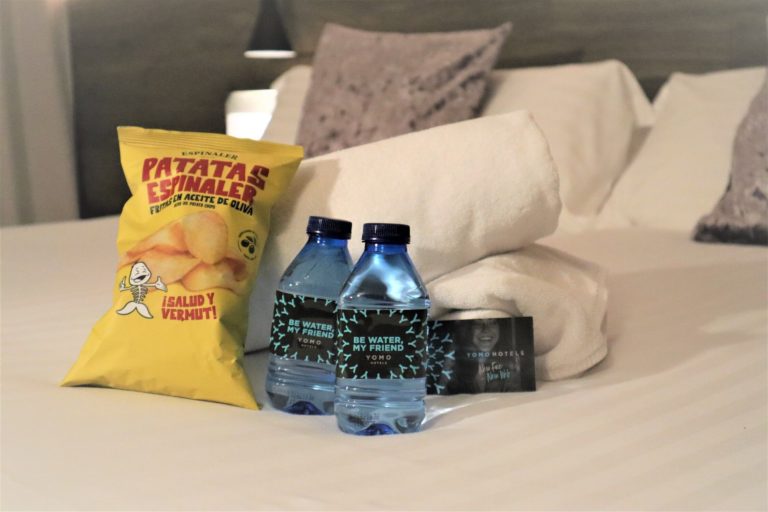 Detalle de Bienvenida en el Hotel Yomo Eureka. 2 botellitas de agua y una bolsa de patatas de la marca Espinaler